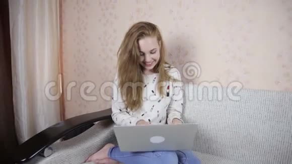 微笑英俊可爱的女孩使用笔记本电脑视频的预览图