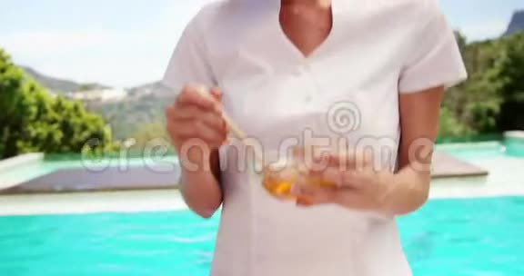 微笑的按摩师拿着一碗蜂蜜视频的预览图