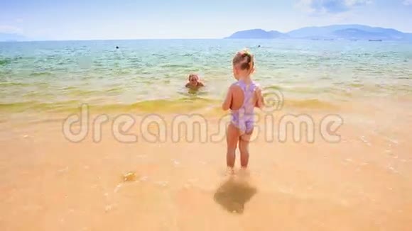 浅海中的金发小姑娘向母亲扔球视频的预览图