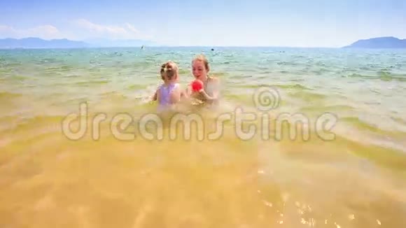 浅海中的金发小姑娘向母亲扔球视频的预览图