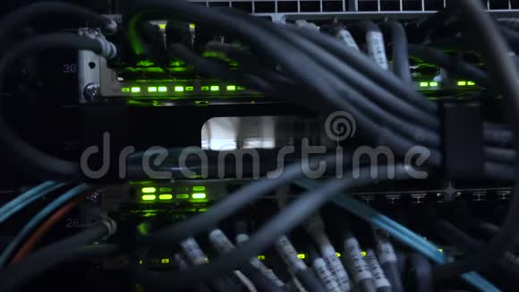以太网网络连接枢纽黑暗服务器机房的闪烁灯光连接到路由器4K的以太网电缆的特写镜头视频的预览图