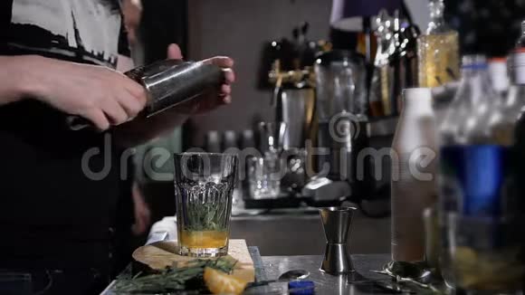 酒保正在做鸡尾酒用冰和草药准备清爽的饮料视频的预览图
