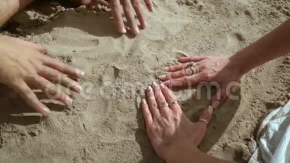 一对手用沙子做成心形爱的象征蜜月假期视频的预览图