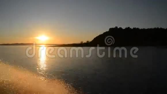 日落时摩托艇漂浮的金色水花视频的预览图