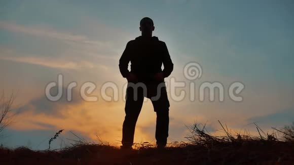 男子战士和尚练习剪影空手道功夫在草地地平线上日落空手道踢腿自我艺术视频的预览图