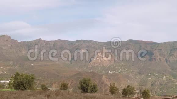 有仙人掌番石榴和金丝雀的山脉从加那利港市中心的观景点观看视频的预览图