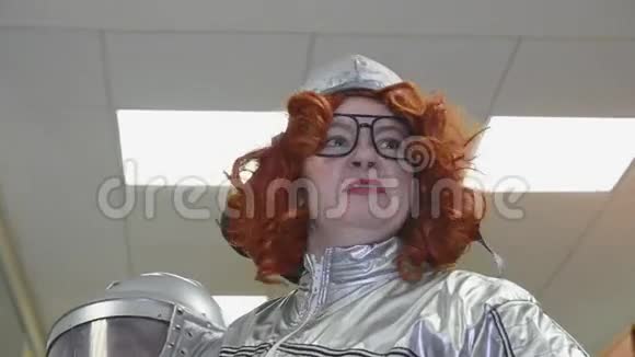 穿灰色太空服的红色卷发的女人说话的眼镜手势手里拿着头盔超现实主义视频的预览图