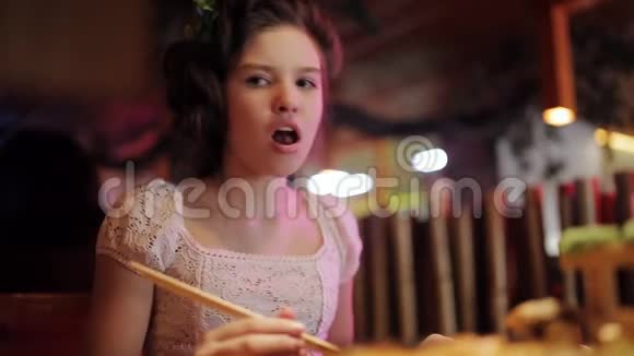 泛亚餐厅的家庭晚餐女孩用筷子吃面包在餐厅里摆着寿司和卷视频的预览图