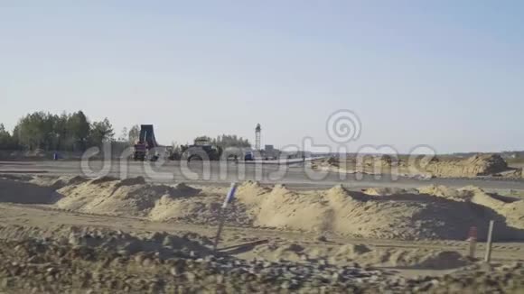 机场跑道道路的建造混凝土男子工人卡车运输工具沥青摊铺机压路机视频的预览图