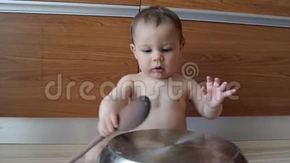 可爱的六个月大的男孩在玩锅和木勺视频的预览图