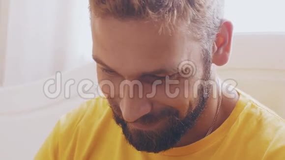 大胡子成年男子穿黄色衬衫在平板电脑上玩游戏的肖像微笑视频的预览图