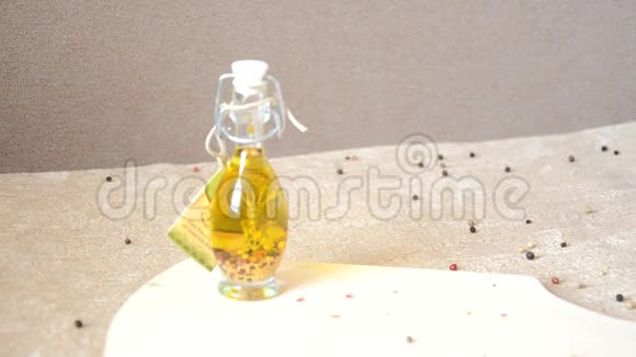 一个装有橄榄油和香料的玻璃瓶在桌子上撒上胡椒视频的预览图
