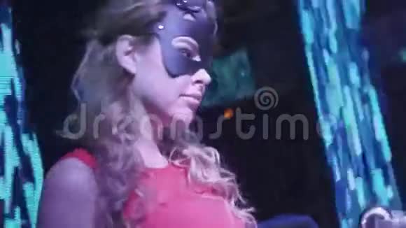 戴着野兔面具的女孩在夜总会转盘上跳舞的红色连衣裙表演者视频的预览图