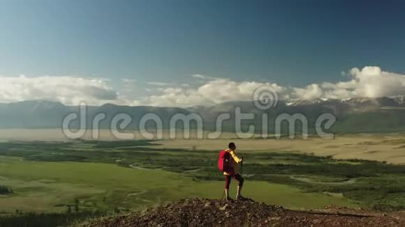 女徒步旅行者在山顶上的空中射击视频的预览图