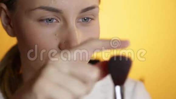 美丽快乐的年轻女士在黄色背景上化妆视频的预览图