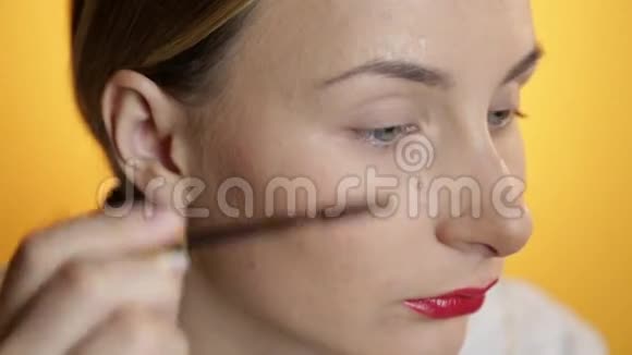 美丽快乐的年轻女士在黄色背景上化妆视频的预览图