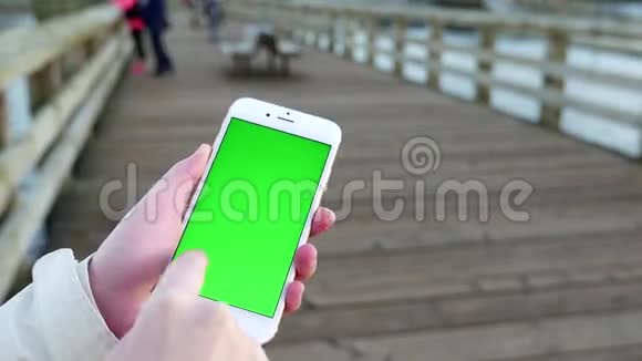 女子手持绿屏显示手机视频的预览图