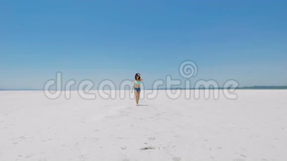 一个女人在塞浦路斯白色的盐湖上散步视频的预览图