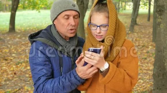 女儿和爸爸在秋天公园的视频上打电话爸爸微笑着和女儿一起笑视频的预览图
