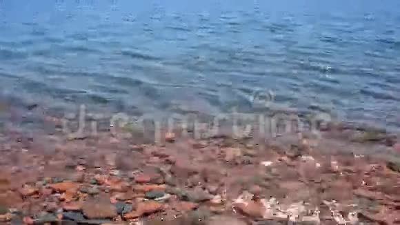 波浪溅在红色和灰色的石头上视频的预览图