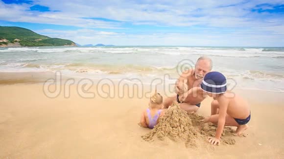 海滩上有湿沙的金发女孩男孩模型城堡视频的预览图