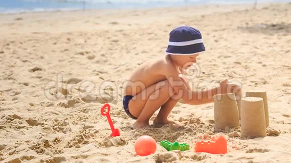 小男孩在帽蹲移动桶做沙蛋糕视频的预览图