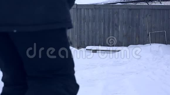 雪夜后工作在一个寒冷的雪天早晨一个拿着铲子把雪从院子里移走的人视频的预览图