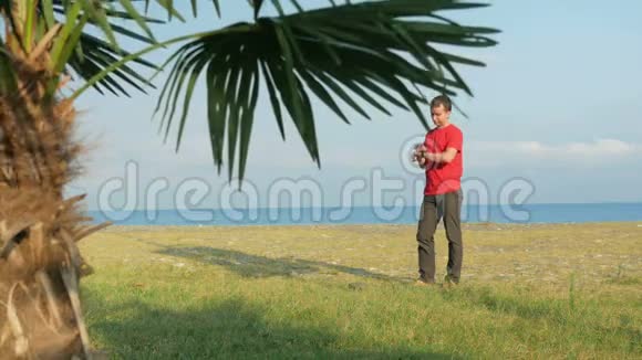 岩石海滩上的那个人前景中的棕榈树负责监控信息的人视频的预览图