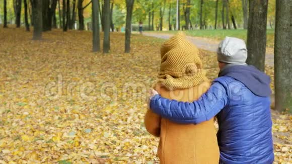 父亲和女儿在秋天的公园里休息爸爸和孩子微笑着看着美丽的风景视频的预览图