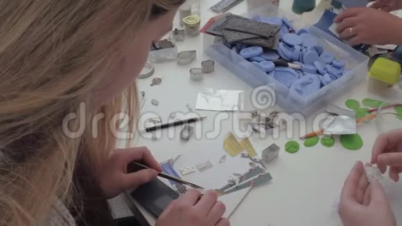 一个年轻女孩正在做一个项目她微笑着俯视着自己的作品视频的预览图