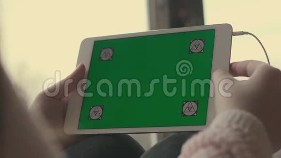 一个拿着绿色屏幕平板电脑的女孩视频的预览图