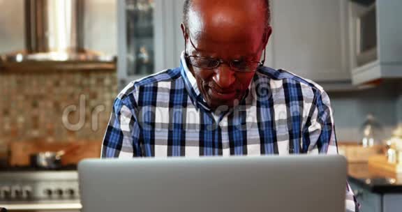 穿着衣服的老人用笔记本电脑视频的预览图