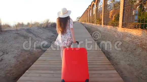 年轻的女人带着红色的手提箱跑视频的预览图