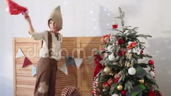 孩子们在圣诞树旁玩耍男孩扔帽子欢乐视频的预览图
