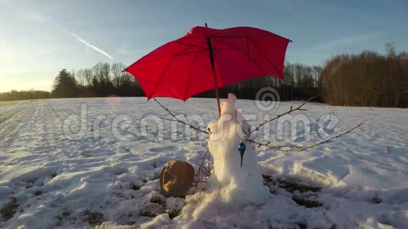 冬季残雪人带红伞时间流逝4K视频的预览图
