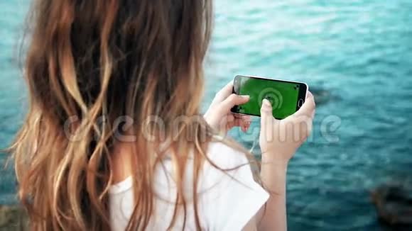 晚海少女手持绿屏智能手机视频的预览图