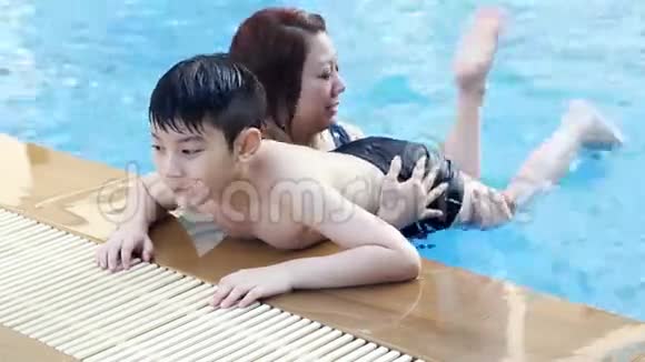 小亚洲男孩和妈妈一起学游泳视频的预览图