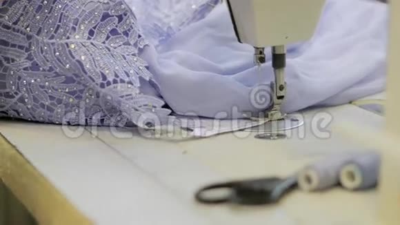一个职业女裁缝正在用缝纫机撕下一件棉衣视频的预览图