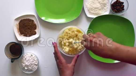 一对已婚夫妇用炼乳椰子刨花和杏仁准备糖果视频的预览图