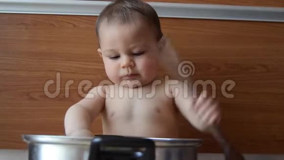 可爱的六个月大的男孩在玩锅和木勺视频的预览图