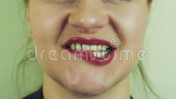 女人用红色的蜜汁在镜头前咬着嘴唇嘴巴微笑舌头视频的预览图