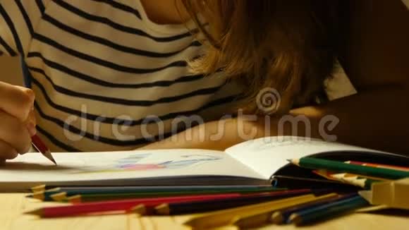 戴眼镜的漂亮女孩画着色书关门视频的预览图