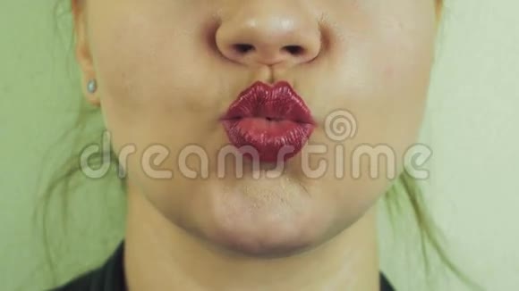 女人带着红色的柚子在镜头前送空气亲吻嘴巴牙齿微笑视频的预览图