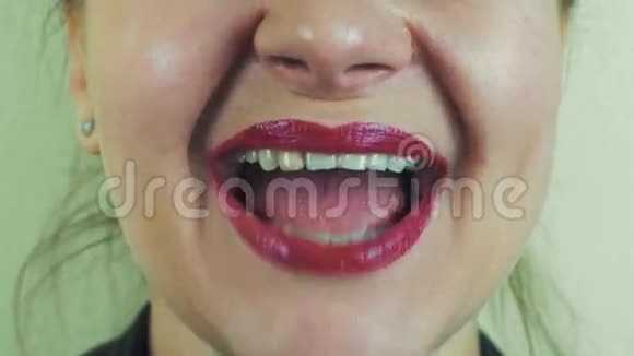 女人带着红色的柚子露出牙齿在镜头前微笑嘴巴面子化妆视频的预览图