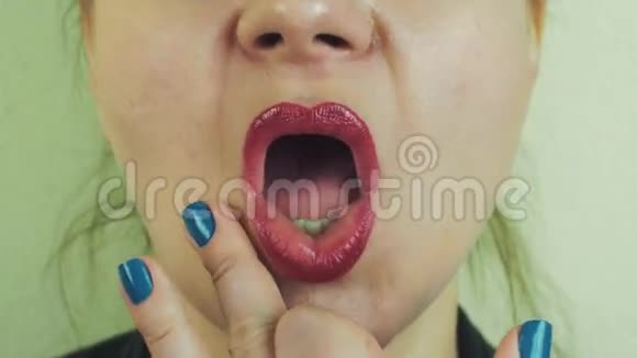 女人用红色的蜜汁触摸前面的镜头扮演猿猴牙齿脸面视频的预览图