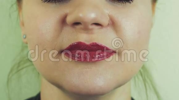 看到女人的嘴唇上有红色的柚子开始在前面的相机唱歌嘴巴牙齿视频的预览图