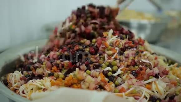 厨师双手混合一份美味的彩色蔬菜沙拉作为素食菜肴的特写视频的预览图