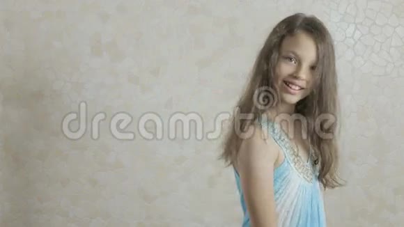 穿着蓝色连衣裙的漂亮女孩快乐地旋转着视频的预览图