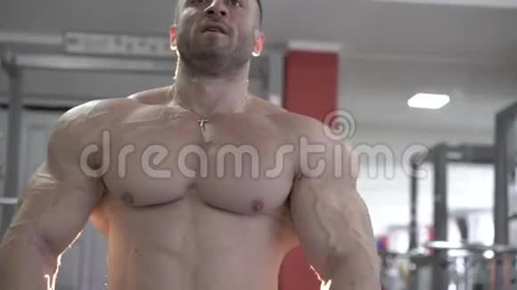 健身馆的肌肉健美者在相机上摆姿势慢慢地视频的预览图