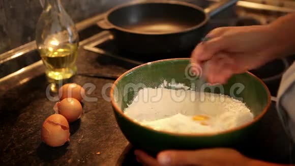 一个厨师把面粉和鸡蛋混合成煎饼面团的慢镜头视频的预览图